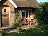 Classic Iroko Adirondack chairs in a cottage garden on the south coast