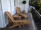 2 Classic Iroko Chairs with footstools and tables on a balcony with views over Lake Geneva
